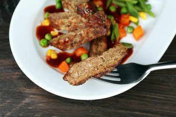 Tasty slices of meat with vegetables on table close up