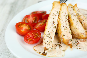 Slices of chicken fillet with spices and cherry tomato on table close up