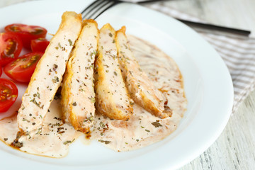 Slices of chicken fillet with spices and cherry tomato on table close up