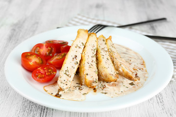 Slices of chicken fillet with spices and cherry tomato on table close up