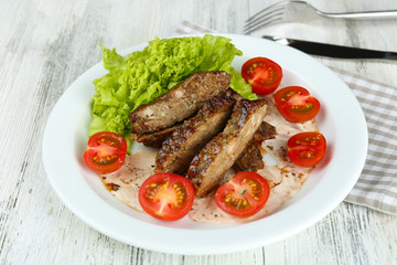 Tasty slices of meat with sauce and cherry tomato on table close up