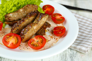 Tasty slices of meat with sauce and cherry tomato on table close up