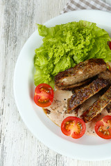 Tasty slices of meat with sauce and cherry tomato on table close up