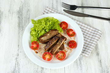 Tasty slices of meat with sauce and cherry tomato on table close up