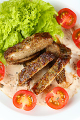 Tasty slices of meat with sauce and cherry tomato on plate close up