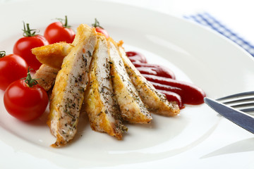 Slices of chicken fillet with sauce and cherry tomato on table close up