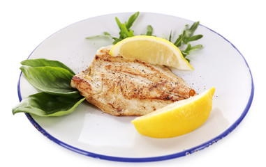 Dish of fish fillet with greens and lemon on plate isolated on white