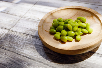 Shot of green soybeans on a wooden table
