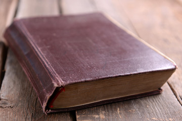 Old book on wooden table close up