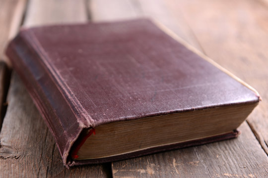 Old book on wooden table close up