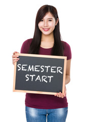 Asian woman with chalkboard showing semester start on board © leungchopan