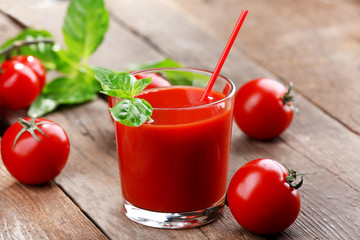 Glass of tomato juice on wooden table, closeup