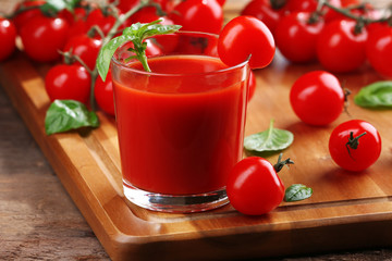Glass of tomato juice on wooden table, closeup