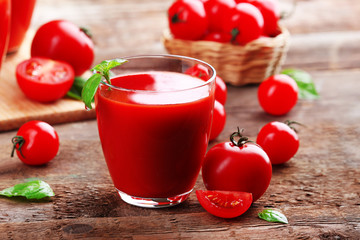 Glass of tomato juice on wooden table, closeup