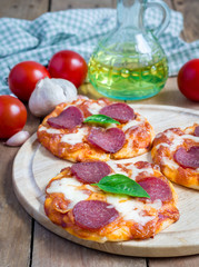 Homemade mini pepperoni pizza on a wooden board