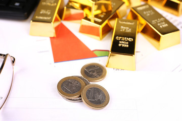 Gold bullion with coins on documents background