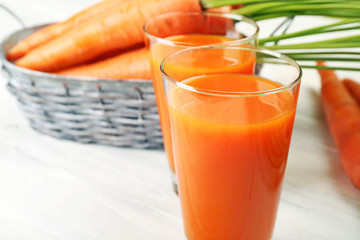 Glasses of carrot juice with vegetables on table close up