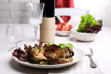 Roasted artichokes on plate, on kitchen table background