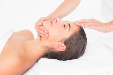 Fototapeta na wymiar Attractive woman receiving head massage at spa center