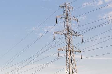 Power pole and power lines on blue sky background