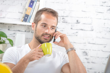 a young business man drinking a cup of coffee