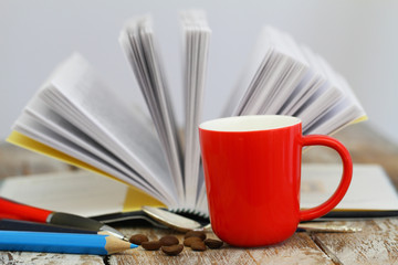 Mug of coffee with open book in the background
