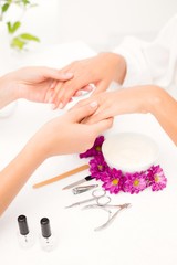 Obraz na płótnie Canvas Beautician filing female clients nails at spa beauty salon