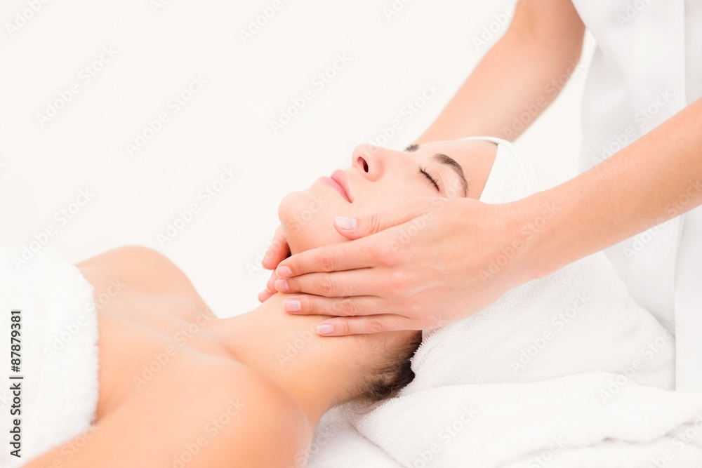 Wall mural Attractive woman receiving facial massage at spa center