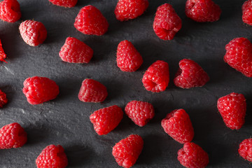 Red sweet raspberries on wooden table close up