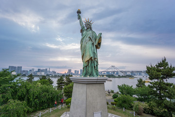 Fototapeta premium Statue of Liberty and Rainbow bridge in Odaiba at sunset