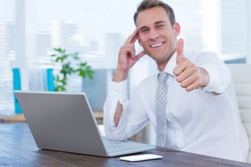 Smiling businessman gesturing thumbs up