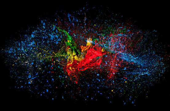high speed photography of an explosion of acrylic colors on a black background. nobody around. concept of art, strength, joy and creativity.