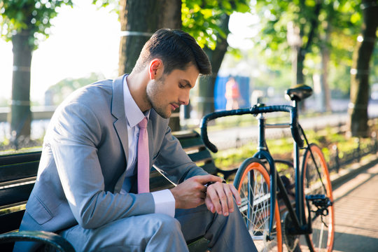Businessman looking on wrist watch outdoors