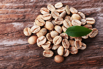 Pile of green coffee beans on wooden table, closeup