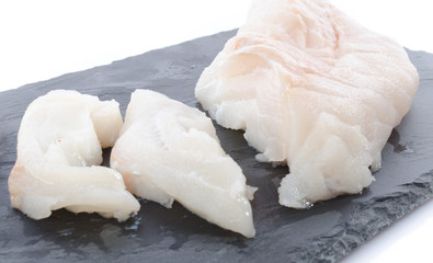 Fresh raw cod fillet on a slate plate