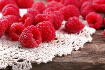 Fresh raspberries on wooden table with napkin, closeup
