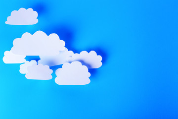 White paper clouds on blue background. Cloud computing concept.
