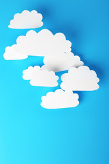 White paper clouds on blue background. Cloud computing concept.