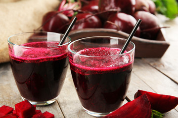 Glass of beet juice on wooden table, closeup
