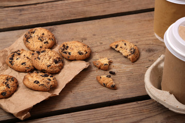 Paper cups of coffee with cookies on wooden table close up