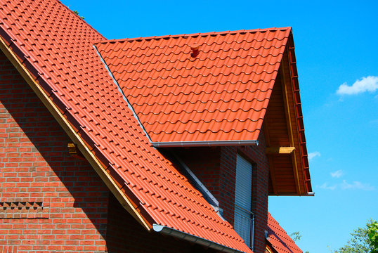 Dach mit roten Dachpfannen an einem schönen Privathaus