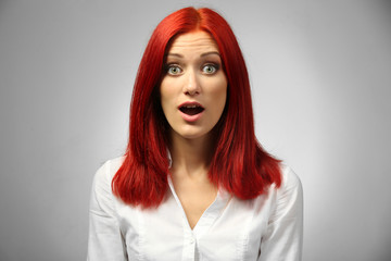 Beautiful young woman on gray background