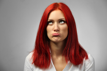 Beautiful young woman on gray background