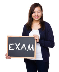 Woman showing the chalkboard with a word exam