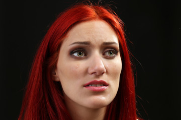 Fototapeta premium Face of young woman with tear drop on dark background