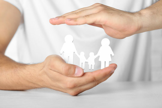 Figurine of family in male hands, closeup