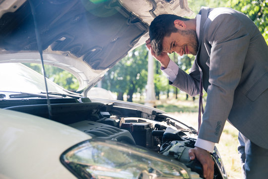 Man Looking Under The Hood Of Car