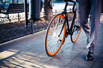 Businessman walking with bicycle