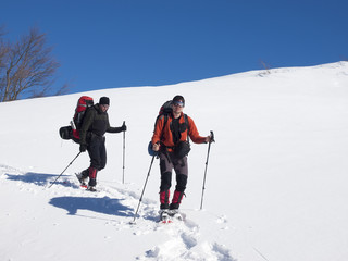 Fototapeta na wymiar Men go snowshoeing in the mountains in the snow.