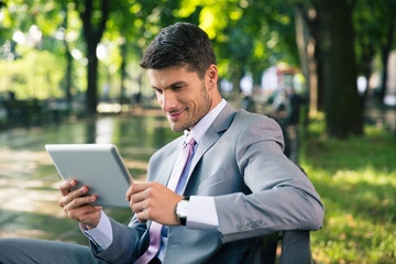 Businessman using tablet computer outdoors